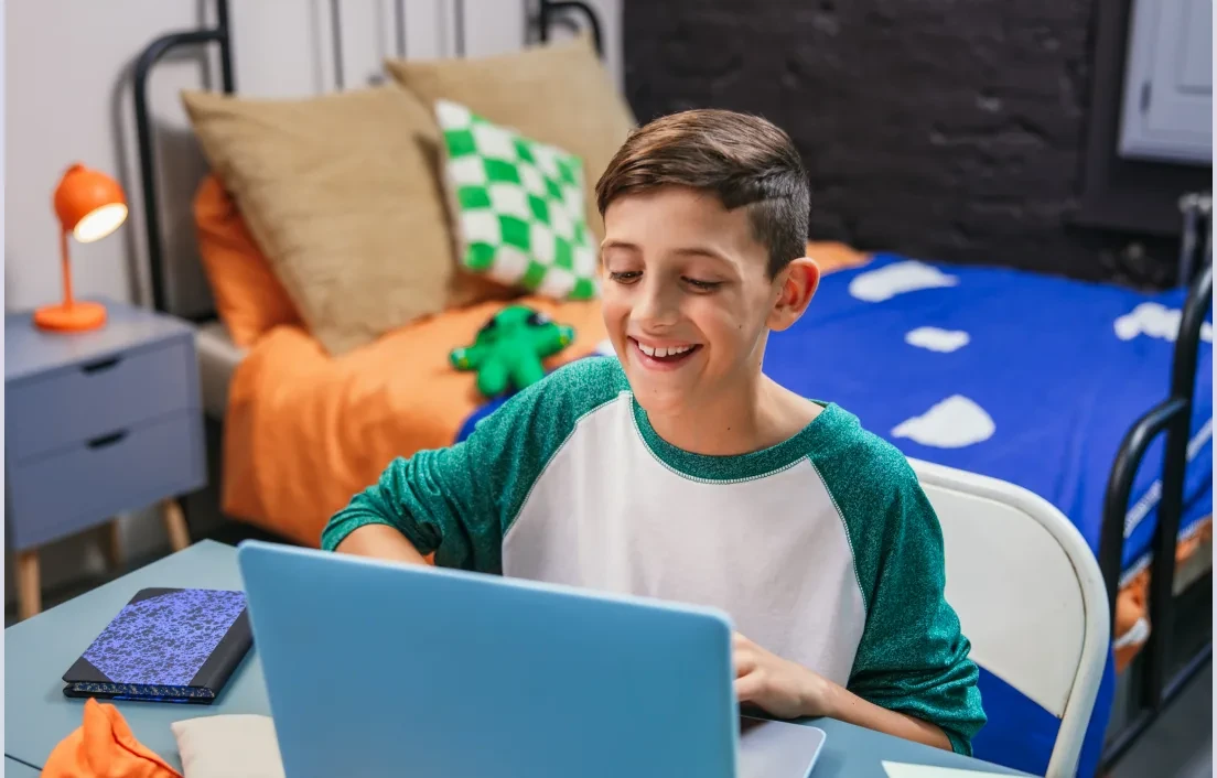 Bambino che impara online con un computer portatile